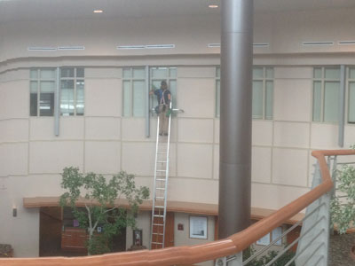 Man on ladder cleaning window